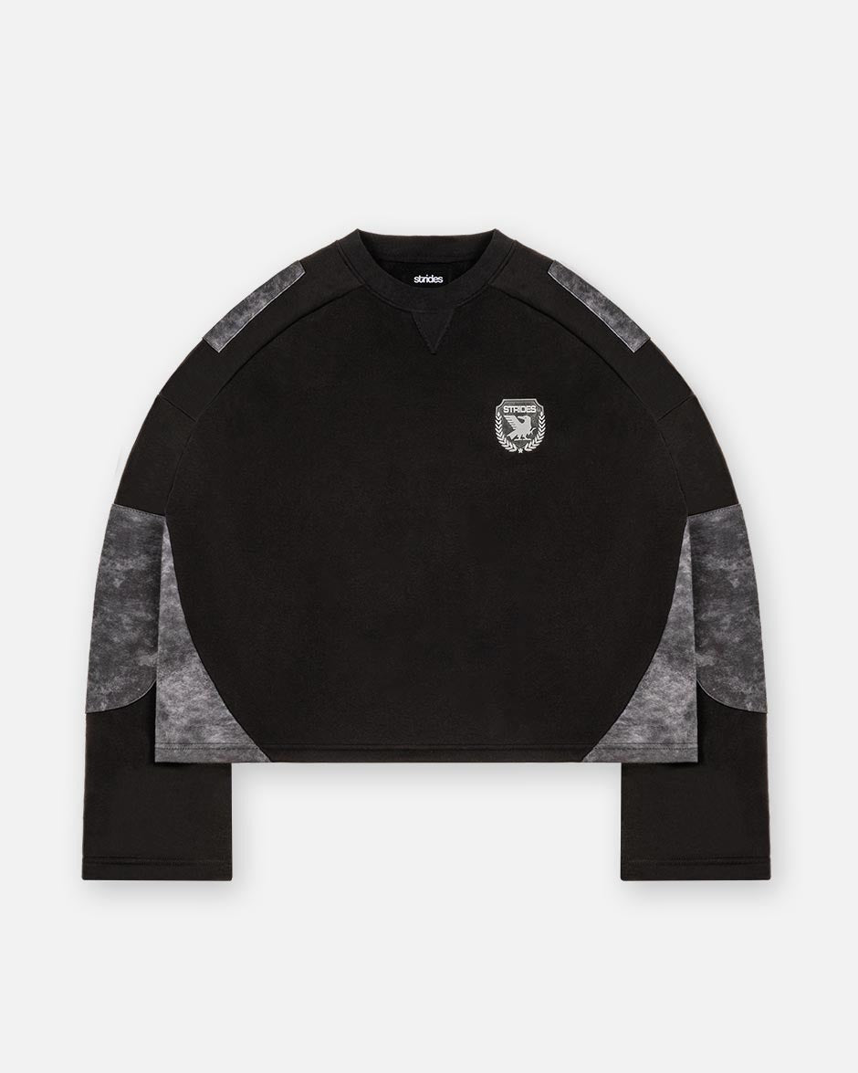 A black longsleeve crop top with alpha black camouflage patches on the sleeves and a logo print on the chest.