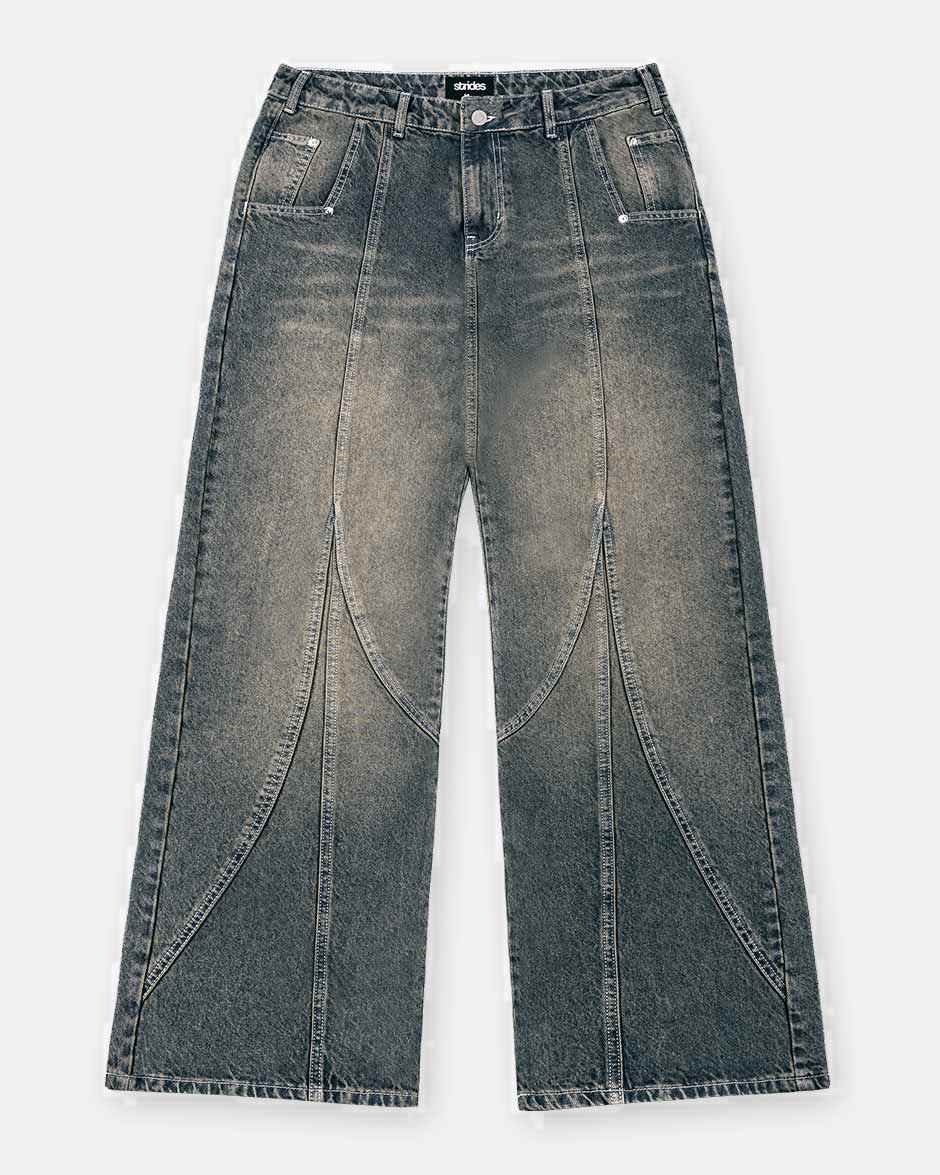 A pair of dark blue denim jeans with a yellow wash and baggy fit, including visible stitching and a button-up front.