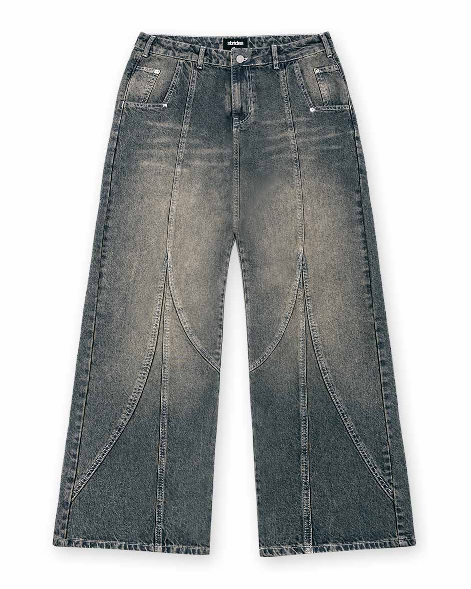 A pair of dark blue denim jeans with a yellow wash and baggy fit, including visible stitching and a button-up front.