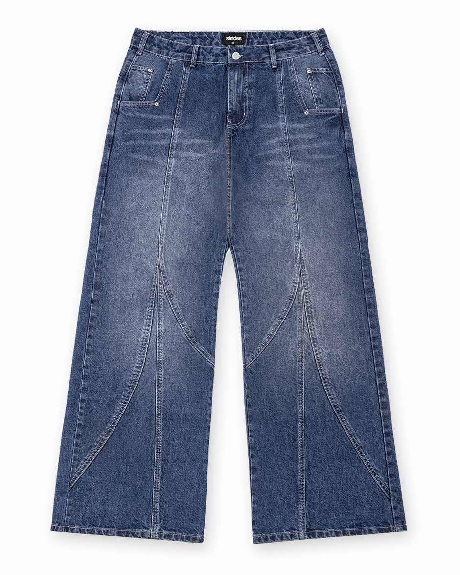 A pair of wide-fit blue denim jeans with visible stitching and leather patch on the back pocket.