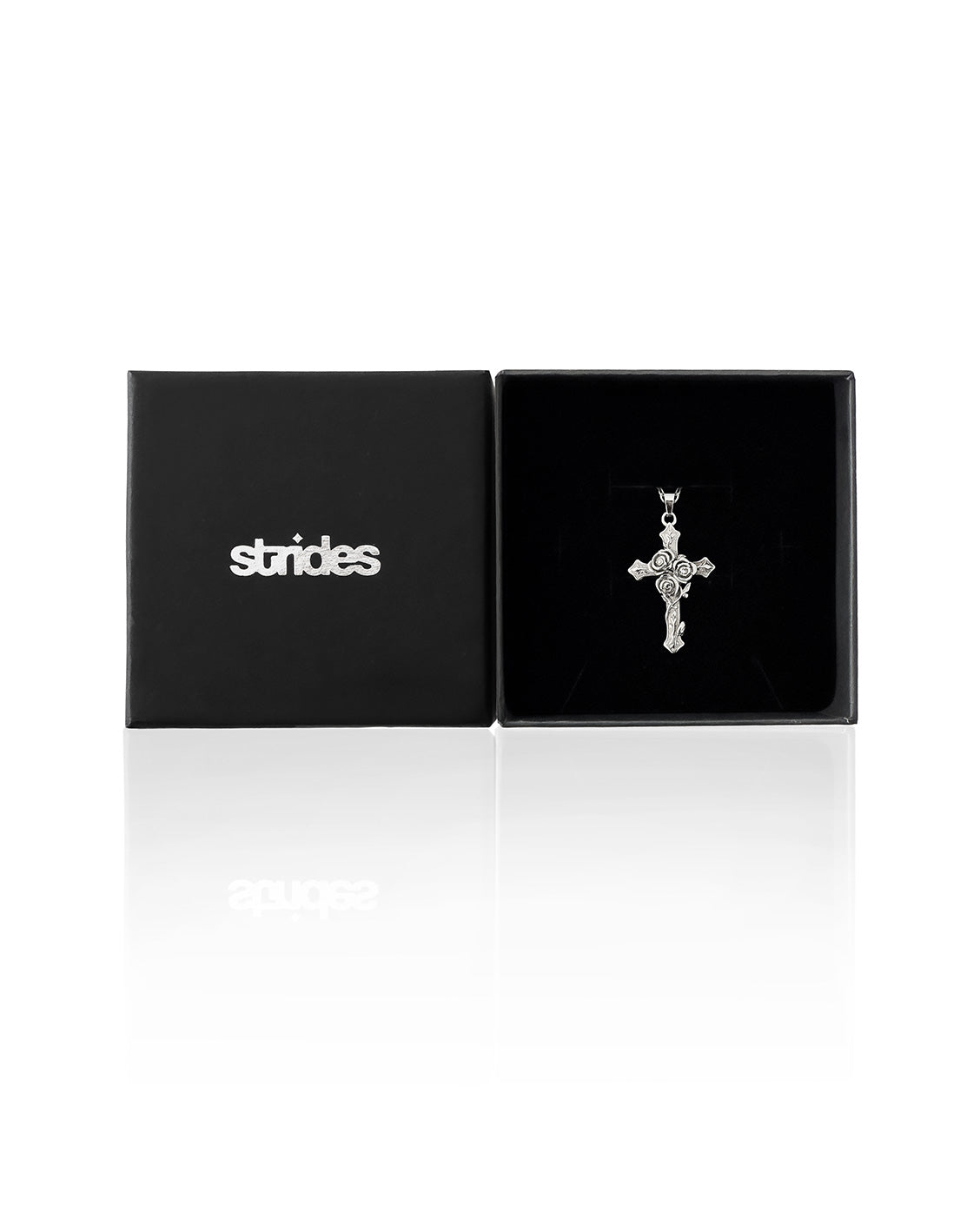 Silver cross pendant in a black 'strides' box on a white background