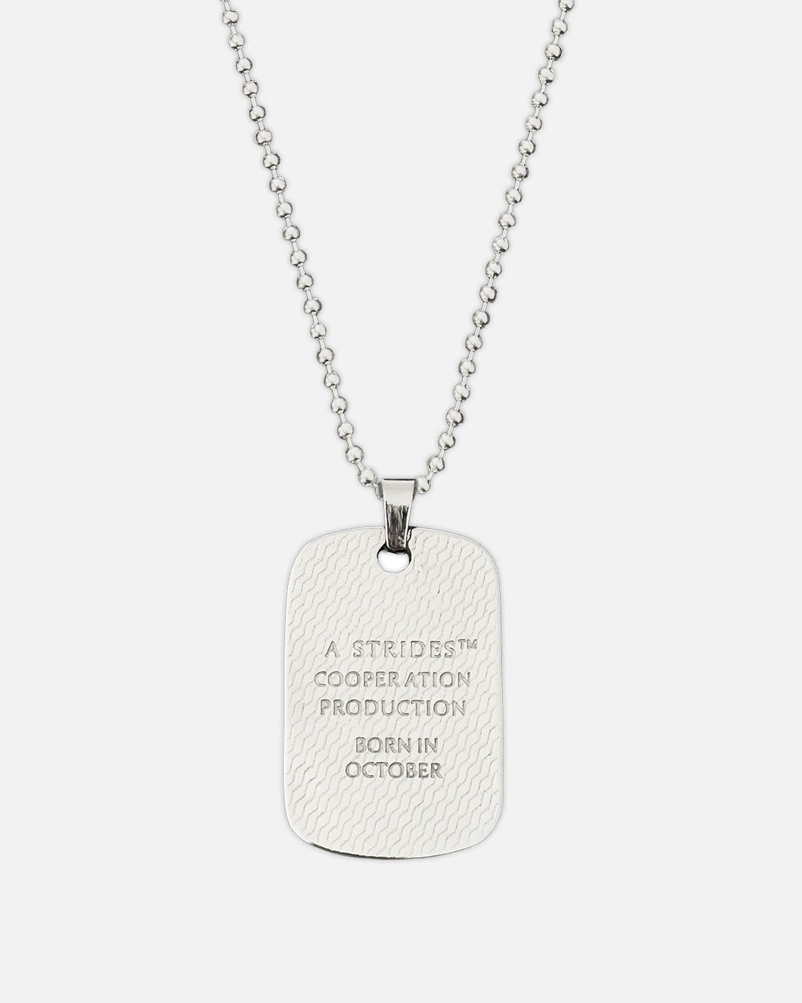 Silver dog tag necklace with engraved text on a white background
