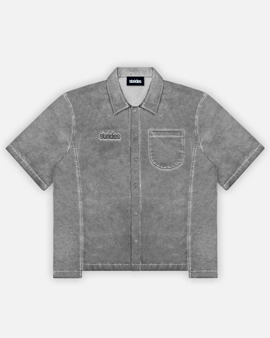 A gray cotton shirt with oil washing and logo embroidery on the chest, featuring a cropped boxy fit with sewing line details.
