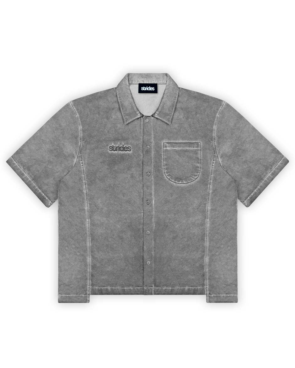 A gray cotton shirt with oil washing and logo embroidery on the chest, featuring a cropped boxy fit with sewing line details.