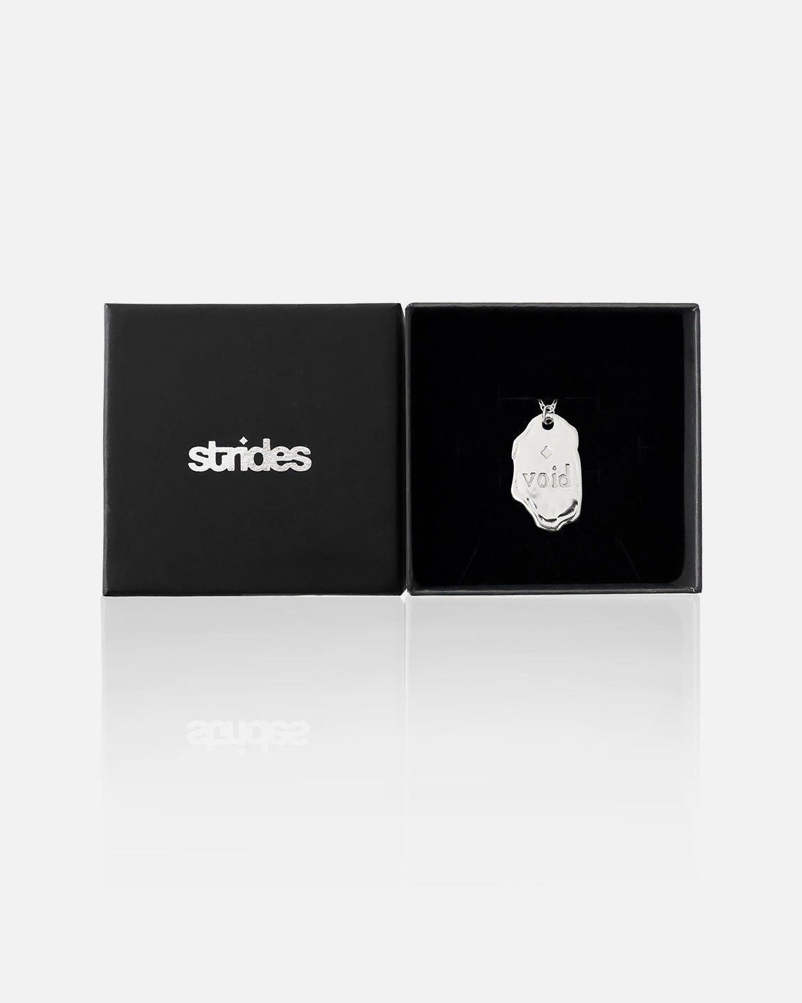 Black box with 'strides' branding and a silver pendant inside on a white background