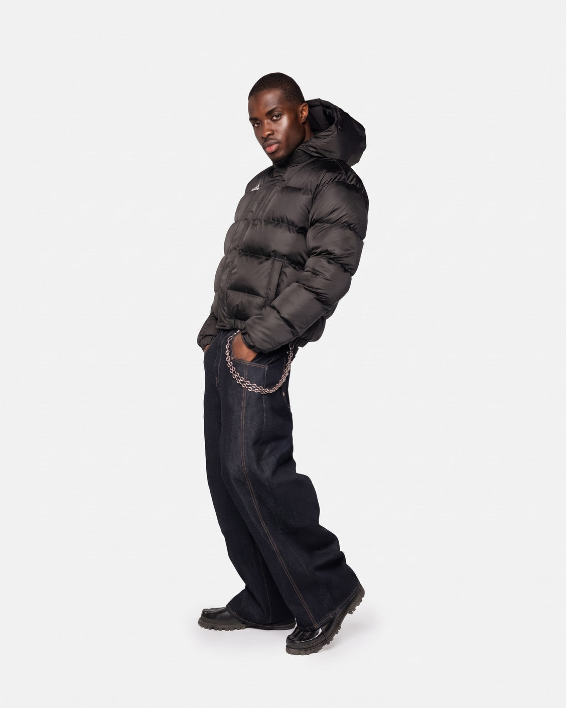 Boční pohled na bundu Apex Puffer Black ukazující cropped boxy fit