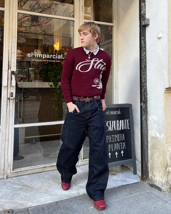 Outside a restaurant, wearing the Echoes Knit Sweater in bordeaux
