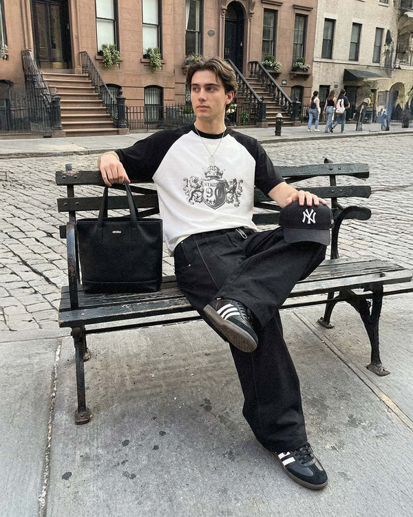 On a New York bench, wearing a Strides crest raglan longsleeve