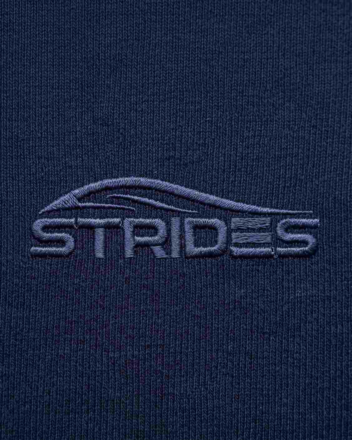 Close-up of the tonal embroidered Strides logo on the navy slim tee