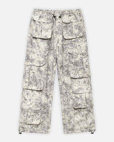 Umas calças cargo bege de camuflado com vários bolsos.