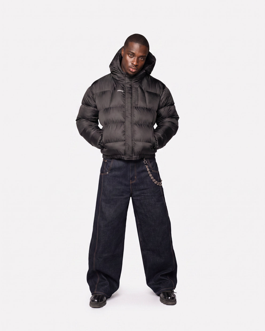 Muž v bundě Apex Puffer Black, pohled zepředu s nasazenou kapucí